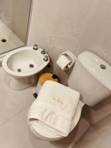 ein weißes Badezimmer mit Toilette und Waschbecken in der Unterkunft Departamento Sofia Soberana in Bahía Blanca
