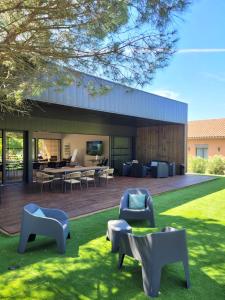 ein Gebäude mit Stühlen und Tischen im Hof in der Unterkunft Hôtel & Events LE PATIO OCCITAN Toulouse Ouest - Cugnaux in Cugnaux