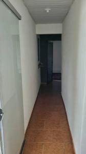 un corridoio con pareti bianche e pavimento piastrellato di Pellin House a Bonito