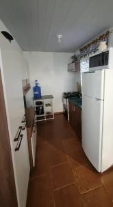 una cucina con frigorifero bianco e pavimento piastrellato di Pellin House a Bonito Altre 5 foto