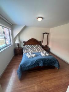 a bedroom with a bed with a blue comforter at Espectacular Apartamento 1-6 huéspedes in Tunja