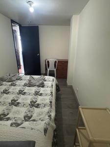 a bedroom with a bed and a chair in it at Espectacular Apartamento 1-6 huéspedes in Tunja +1 photo