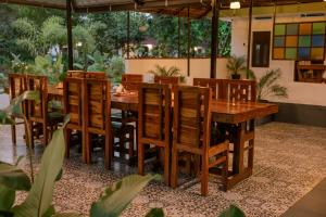 a dining room with a wooden table and chairs at Ayurprana Marari in Mararikulam