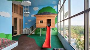 ein Zimmer mit einem Spielzimmer mit einem Haus auf einer Rutsche in der Unterkunft Springwood At By LiviRooms Tangerang in Tangerang