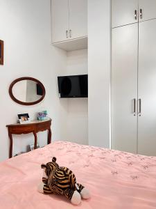 a zebra stuffed animal sitting on a pink bed at Angra Sea House in Angra dos Reis