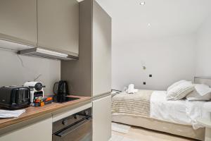a small bedroom with a bed and a kitchen at MyHotel - Suite Tête d'Or, Cordelier in Lyon
