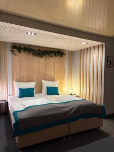 ein Schlafzimmer mit einem großen Bett und blauen Kissen in der Unterkunft Hotel Sokak in Sarajevo