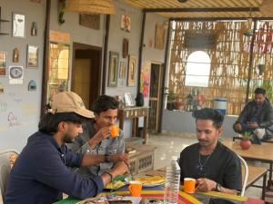 een groep mannen die aan een tafel eten bij Incredible's Hostel & Safari in Jaisalmer +59 foto's