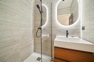 ein Badezimmer mit Dusche, Waschbecken und Spiegel in der Unterkunft MyHotel - Suite Tête d'Or, Cordelier in Lyon + 7 Fotos