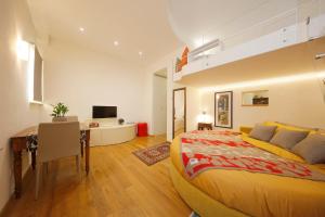 a bedroom with a large bed and a desk at Siena UpTown - Sabrina's Cozy Apartment in Siena