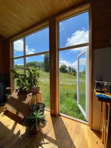 a room with a window with a view of a field at Casa Azul Frutillar in Frutillar
