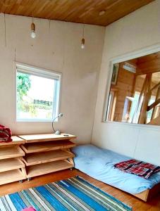 ein kleines Schlafzimmer mit einem Bett und einem Fenster in der Unterkunft Casa Azul Frutillar in Frutillar