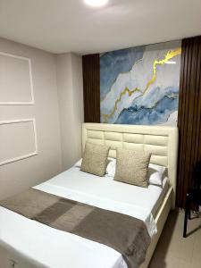 En eller flere senge i et værelse på Hospedaje GRAND H Rodadero & Suite