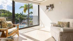 a living room with a couch and a balcony at Tranquility at MoonBay B - 304 in Key Largo