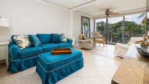 a living room with a blue couch and a balcony at Tranquility at MoonBay B - 304 in Key Largo