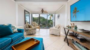 a living room with a blue couch and a tv at Tranquility at MoonBay B - 304 in Key Largo