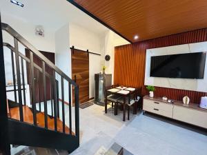 a living room with a large television and a table at Tim's Guest House in Butuan