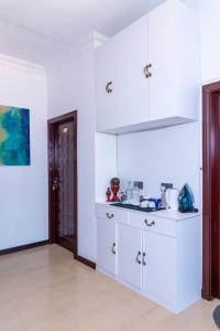 a kitchen with white cabinets and a sink at Samaik Thulusdhoo in Thulusdhoo
