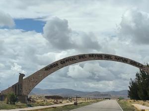 a stone arch with writing on it on a road at Hacienda Esmeralda in Ñuñoa