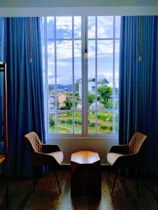 a window with two chairs and a table in front of it at New Pensive Villa in Nuwara Eliya +15 photos