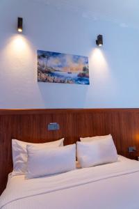 ein Schlafzimmer mit einem Bett und zwei weißen Kissen in der Unterkunft Samaik Cottage in Thulusdhoo