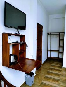 a living room with a tv on a wall at New Pensive Villa in Nuwara Eliya