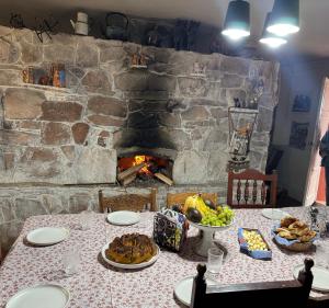 a table with food and a stone fireplace at Hacienda Esmeralda in Ñuñoa