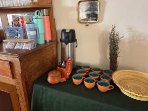 a table with a group of cups on a table at Hacienda Esmeralda in Ñuñoa