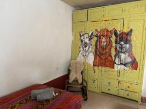 a bedroom with a painting of dogs on the wall at Hacienda Esmeralda in Ñuñoa