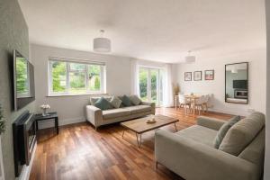a living room with two couches and a table at 4 Bed House, MK Centre with Parking Contractor & Family Friendly in Haversham
