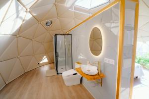 een badkamer met een spiegel en een wastafel in een koepelhuis bij Glamping El Refugio in Archidona