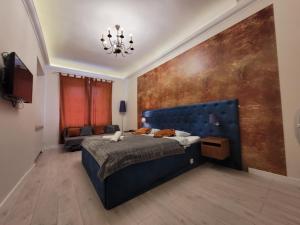 a bedroom with a blue bed and a large wall at Chmielna 5 Rooms & Apartments in Warsaw