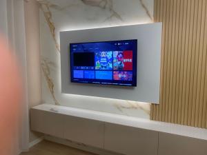 een flatscreen-tv aan een muur in een kamer bij Cherry Apartments in Shkodër