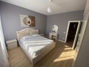 een slaapkamer met een bed en een spiegel aan de muur bij Cherry Apartments in Shkodër