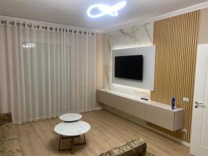 een woonkamer met een flatscreen-tv en een bank bij Cherry Apartments in Shkodër