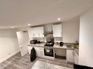 eine Küche mit weißen Schränken und einer Arbeitsplatte in der Unterkunft Flexy Students Room 1 in Gloucestershire