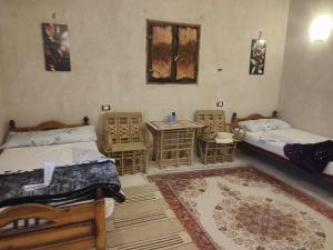 una camera con due letti, un tavolo e un tappeto di إيتران - Itran a Siwa Altre 8 foto