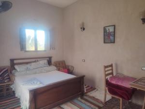 una camera da letto con un letto e una scrivania di إيتران - Itran a Siwa