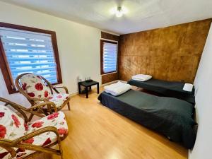 a bedroom with two beds and a chair and a window at Mamisà 3, appartamento con giardino privato in Schio