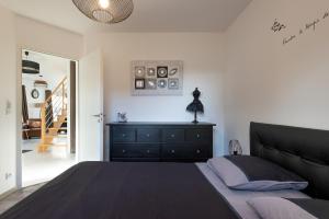 a bedroom with a bed and a dresser and a staircase at L'air de Riez in Saint-Hilaire-de-Riez