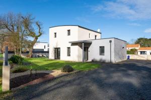 a white house with a driveway in front of it at L'air de Riez in Saint-Hilaire-de-Riez