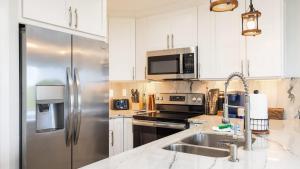 a kitchen with white cabinets and a stainless steel refrigerator at Saltair Loft Ocean Pointe 2 BR 2 BA 1411 in Tavernier