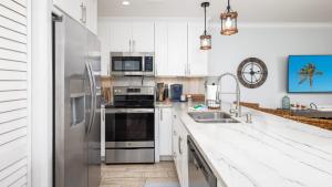 a kitchen with white cabinets and a stainless steel refrigerator at Saltair Loft Ocean Pointe 2 BR 2 BA 1411 in Tavernier