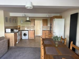 a kitchen with a table and a kitchen with a refrigerator at Yellow Sunflowers Flat In Stroud in Stroud +2 photos