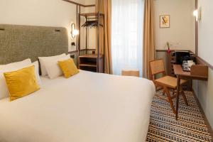 a hotel room with a large bed and a desk at Best Western Plus Au Grand Saint Jean in Beaune