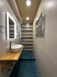 a bathroom with a sink and a mirror and blue floors at Fairytale Apartment in Aghk'ilisa