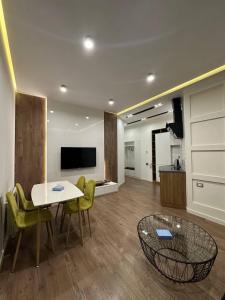 a living room with a table and chairs and a kitchen at Fairytale Apartment in Aghk'ilisa