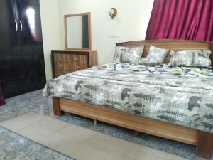 a bedroom with a bed and a dresser and a mirror at KOOZE Integrated Services Ltd 