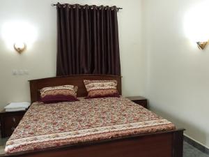 a bed with two pillows on it in a bedroom at KOOZE Integrated Services Ltd 