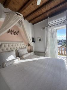 una camera da letto con un letto bianco e una finestra di Villa Erika ad Agios Ioannis